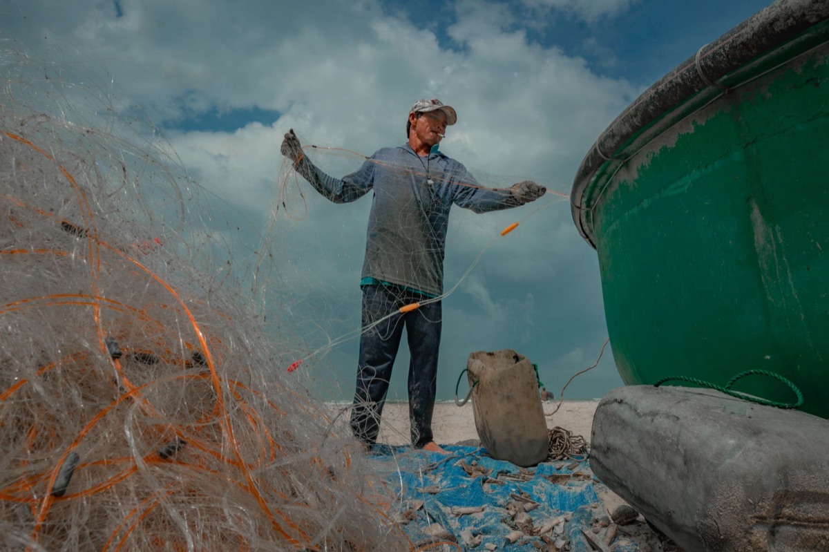 Bahamian fisherman with net and boat