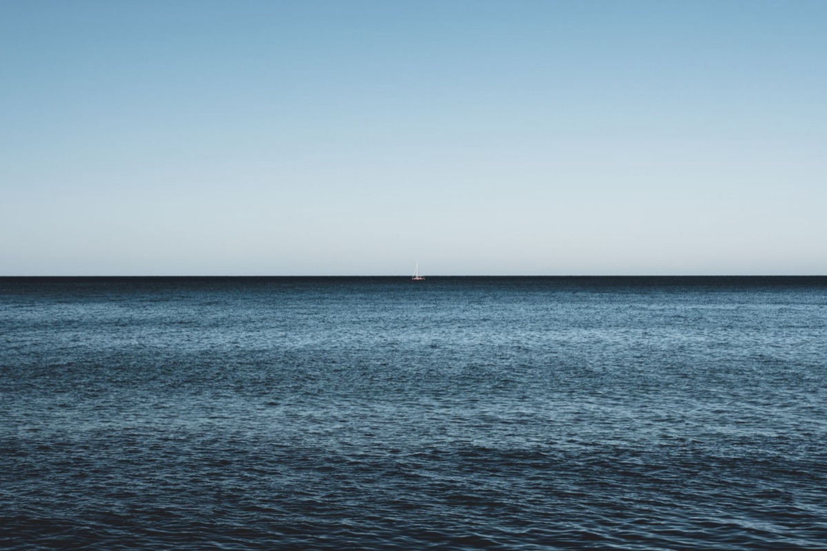 Barco a distancia en el mar azul