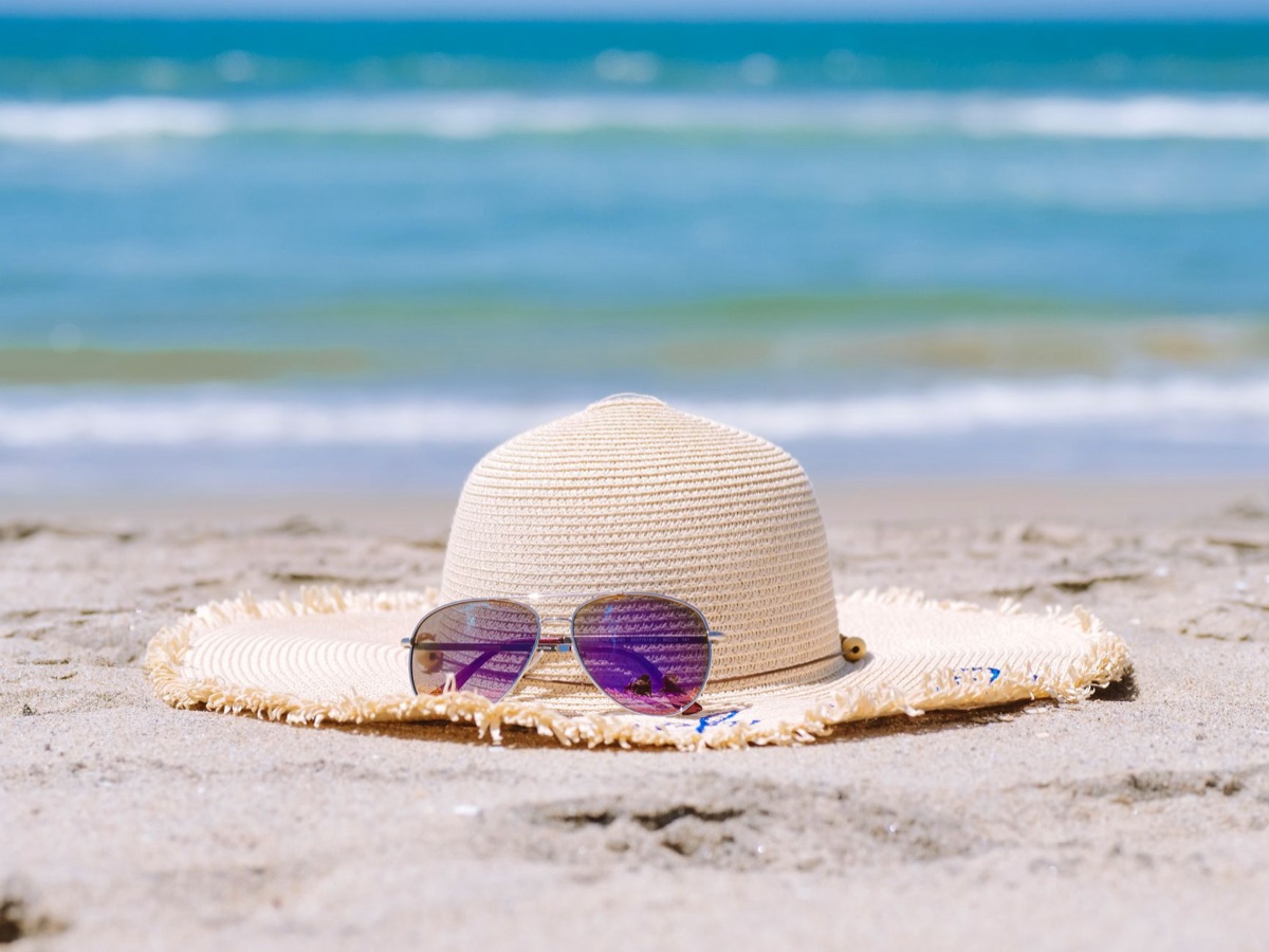 Sonnenschutzmittel und Badebekleidung auf Strand