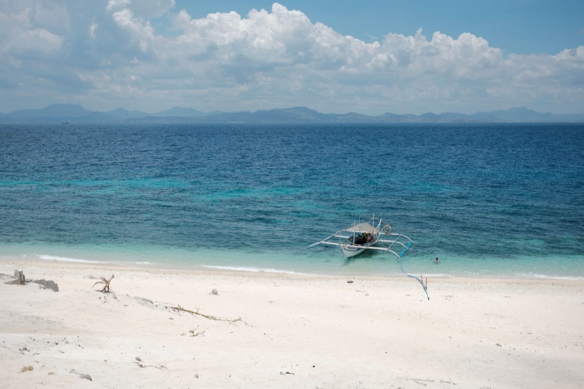 Barco blanco en una playa tropical