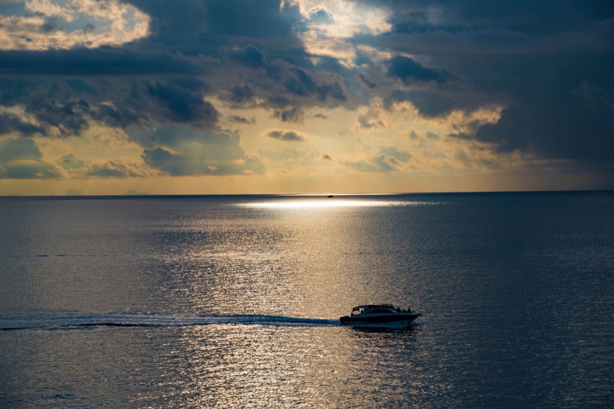 アメリカからの旅人はバハマの砂浜で夕陽を見ている
