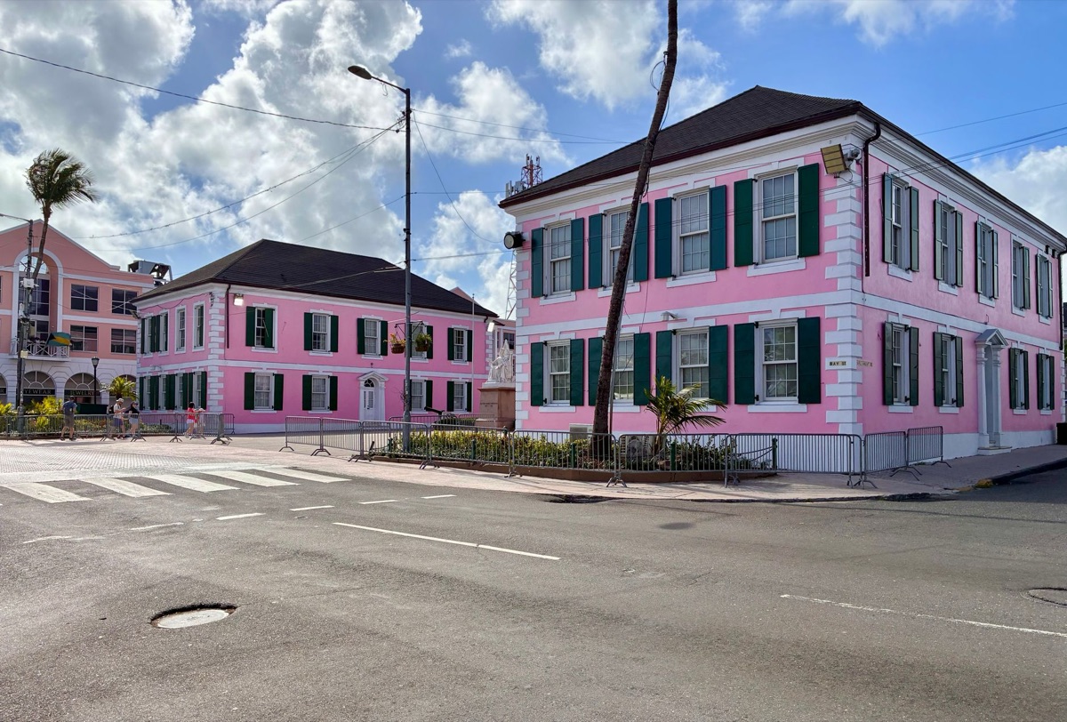Una foto di un gruppo di membri della Royal Family in Bahama, con un'antica costruzione di fondo.